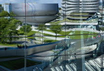 Germany, Bavaria, Munich, BMW Headquarters and museum reflected in BMW Welt, World.