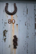 Detail of door with lucky horse shoe and scottish piper door knocker.European DoorKnockerHorseshoeLuckLucky Alba Equestrian Great Britain Northern Europe UK United Kingdom