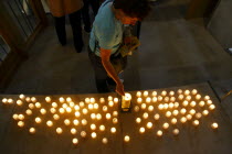 Nuemarkt  Dresdner Frauenkirche church of Our Lady. People lighting candles by the original Cross from the roof. Lutheran Church bombed in 1945 and rebuilt using original and new stones. Re-opened in...