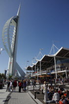 Gunwharf Quay.  Spinnaker tower with tourists sat on steps outside cafes at the base.Gun Wharf Blue European Great Britain Holidaymakers Northern Europe Tourism Tourist UK United Kingdom  Spinaker Sa...