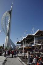 Gunwharf Quay.  Spinnaker tower with tourists sat on steps outside cafes at the base.Gun Wharf Blue European Great Britain Holidaymakers Northern Europe Tourism Tourist UK United Kingdom  Spinaker Sa...