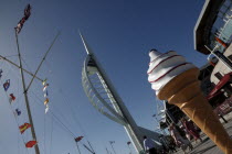 Gun Wharf Quay. Spinnaker Tower and boardwalk with naval flag pole and large plastic Ice Cream Cone in the foreground.Gunwharf Blue European Great Britain Holidaymakers Northern Europe Tourism Touris...