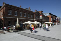 Gun Wharf Quay. Tourists and shoppers walking along canalside past the Old Customs House pub and restaurant.Bar Cafe Custom Public House Gunwharf Blue European Great Britain Holidaymakers Northern Eu...