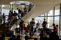 England, East Sussex, Bexhill on Sea, De La Warr Pavilion. Interior of the Art Deco Gallery and Arts Centre. Band performance under the stairwell from the Wilkomen Collective group including the Leisu...