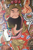 Thailand, Chiang Mai, Pung Tao Gong Ancestral Temple, Close up of a colourful mural depicting a male deity.