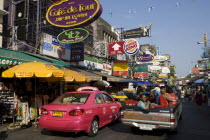 Thailand, Bangkok, Khaosan Road, Pink Taxi parked beneath colourful advertising signs.