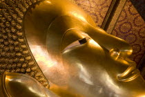 Thailand, Bangkok, Wat Pho, Wat Phra Chetuphon, Close up of the face of the large reclining buddha statue.