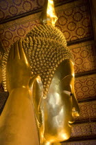 Thailand, Bangkok, Wat Pho, Wat Phra Chetuphon, Close up of the face of the large reclining buddha statue.