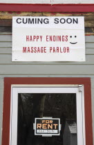USA, New Hampshire, Keene, Sign on building, cuming soon, Happy Endings Massage Parlor.  Possibly written by an illiterate funny man.