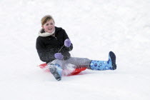 Weather, Winter, Snow, Young girl sledding down hill  in Perth Scotland during January 2010.