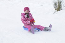 Weather, Winter, SnowYoung girl sledding down hill, Perth, Scotland.