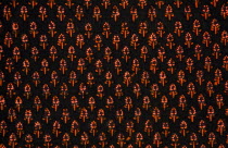 India, Rajasthan, Colourful black and orange patterned textile block print on cloth fabric.