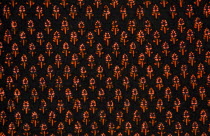 India, Rajasthan, Colourful black and orange patterned textile block print on cloth fabric.