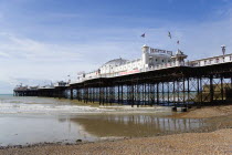 England, East Sussex, Brighton, The Pier at low tide with shingle pebble beach in foreground.