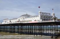 England, East Sussex, Brighton, The Pier at low tide with people walking on the pier