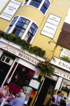 England, East Sussex, Brighton, The Lanes English's Oyster Bar and Seafood Restaurant exterior with people sitting at a table eating lunch and a waiter by the entrance.