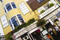 England, East Sussex, Brighton, The Lanes English's Oyster Bar and Seafood Restaurant exterior with a waitress carrying a cup of coffee and a waiter by the entrance.