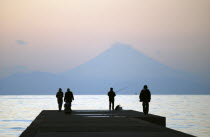 Japan, Honshu, Chiba, Tateyama,  sightseers and fisherman on pier, across Tokyo Bay Mount Fuji visible.