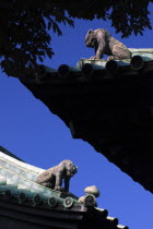 Japan, Tokyo, Kanda, Yushima Seido Confucian Shrine, detail of roof of compound surrounding wall, distinctive guardian tiger figures at corners.