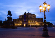 GERMANY, Saxony, Dresden, The restored Baroque Sachsische Staatsoper or State Opera House in Theatre Square first built in 1841 by architect Gottfried Semper illuminated at sunset with an equestrian s...