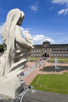 GERMANY, Saxony, Dresden, The central Courtyard and Picture Gallery of the restored Baroque Zwinger Palace gardens busy with tourists seen from the statue lined Rampart originally built between 1710 a...