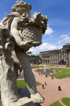 GERMANY, Saxony, Dresden, The central Courtyard and Picture Gallery of the restored Baroque Zwinger Palace gardens busy with tourists seen from the statue lined Rampart originally built between 1710 a...