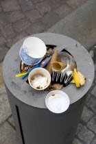GERMANY, Saxony, Dresden, Street litter bin on pavement sidewalk full of rubbish.