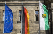 GERMANY, Saxony, Dresden, The flags of the EU European Union, Germany and Saxony flying from flagpoles in front of the Neues Standehaus.