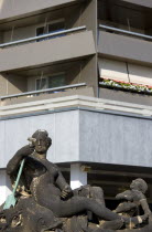 GERMANY, Saxony, Dresden, Statue of a naked reclining woman and a laughing cherub in front of an apartment building in Neustdter market square.