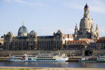 GERMANY, Saxony, Dresden, The city skyline with cruise boats moored on the River Elbe in front of the embankment buildings on the Bruhl Terrace busy with tourists of the Art Academy and the restored B...