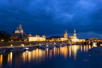 GERMANY, Saxony, Dresden, The city skyline at night with cruise boats moored on the River Elbe in front of the illuminated embankment buildings on the Bruhl Terrace of the Art Academy, the restored Ba...