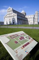 ITALY, Tuscany, Pisa, Campo dei Miracoli or Field of Miracles with a map guide on the grass of the Piazza del Duomo with the Duomo Cathedral church and  Leaning Tower belltower or Torre Pendente with...