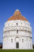 ITALY, Tuscany, Pisa, Campo dei Miracoli or Field of Miracles with the Baptistry under a blue sky.