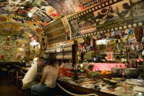 ITALY, Tuscany, Siena, The Bella Vista Social Pub Cuban theme bar interior with people sitting on stools at the bar counter.