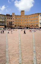 ITALY, Tuscany, Siena, The Piazza del Campo and surrounding buildings with tourists walking in the square.