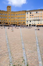 ITALY, Tuscany, Siena, The Piazza del Campo and surrounding buildings with tourists walking in the square.