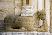 ITALY, Tuscany, San Quirico D'Orcia, The Collegiata Church of the saints Quirico and Giulitta. Sandstone carving of a lion, possibly Etruscan, at the base of a caryatid or zoomorphic column of the ent...
