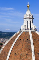ITALY, Tuscany, Florence, The Dome of the Cathedral of Santa Maria del Fiore the Duomo by Brunelleschi with tourists on the viewing platform looking over the city towards the surrounding hills.