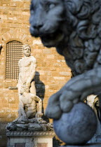 ITALY, Tuscany, Florence, The 1533 statue of Hercules and Cacus by Bandinelli seen through the legs of a stone lion outside the Loggia del Lancia or di Orcagna beside the Palazzo Vecchio in the Piazza...