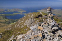 IRELAND, County Galway, Connemara, Diamond Hill, Stone pile at the summit of the hill with Ballynakill Harbour below. 