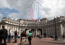 ENGLAND, London, The Mall and Horseguards, Admiralty Arch, People are looking at flying military aircrafts on formation which are leaving colored line trails behind them, as part of Queen of Englands...