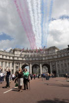 ENGLAND, London, The Mall and Horseguards, Admiralty Arch, People are looking at the colored line trails that were left from flying military aircrafts on formation, as part of Queen of Englands Elisa...