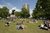 ENGLAND, London, Hyde Park, People sunbathing on a sunny day with blue sky and white clouds, at Hyde Park just in front of Achilles statue, while they are waiting for the world naked bike ride parade...