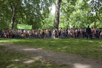 ENGLAND, London, Hyde Park, Naked people with their bicycles on formation, gathered together under the shade of the trees, waiting for the world naked bike ride protest parade to start.