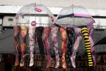 ENGLAND, London, Camden Town, Fake legs with colorful tights and open umbrellas above them, hanged on a wall as part of a shops decoration at famous Camden Town market.
