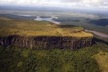 VENEZUELA, Bolivar State, Canaima National Park, Tepui mountain surrounded by a forest and a river shoot from above