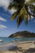 VENEZUELA, Margarita Island, Playa la Galera, View of exotic beach with palm trees and their shades on the sand, just in front of fishing boats floating at the tropical crystal clear seawaters, shot o...