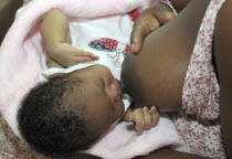 HAITI, Isla de la Laganave, Mother breast feeding young baby.