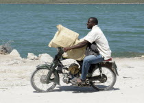 Haiti, Isla de Laganave, Man transporting goods on motorcycle.