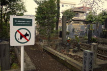Japan, Tokyo, Nippori, sign in cemetary, remove dog waste from park, accompanying picture of dog and waste.